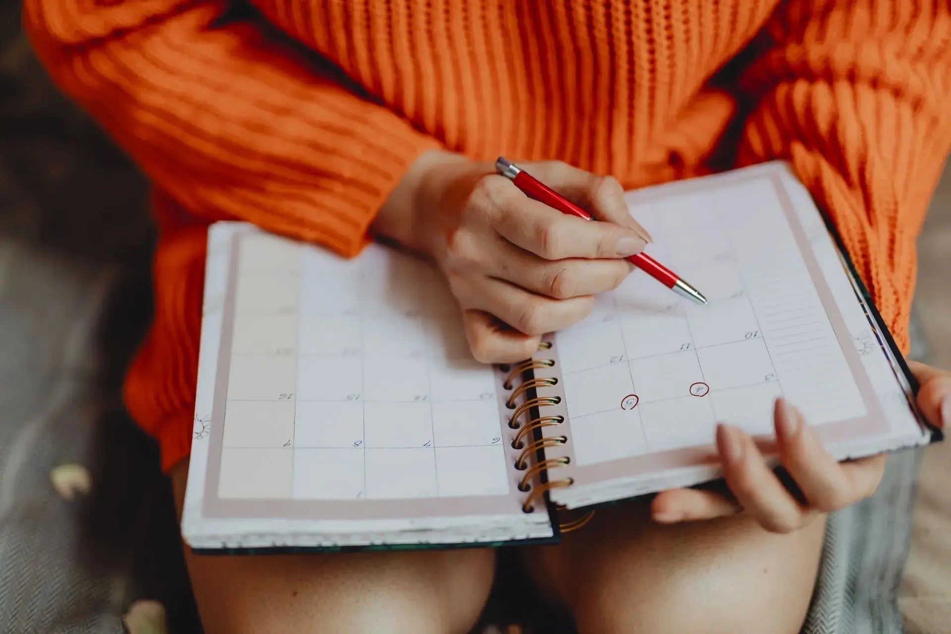 Femme notant les dates de ses règles sur un calendrier pour suivre son cycle menstruel et ses différentes phases. Image