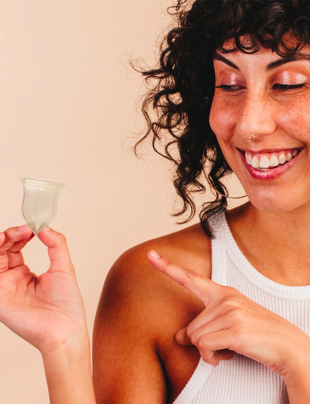 Image optimisée pour le mobile montrant une jeune femme tenant une cup menstruelle Luneale dans sa main 